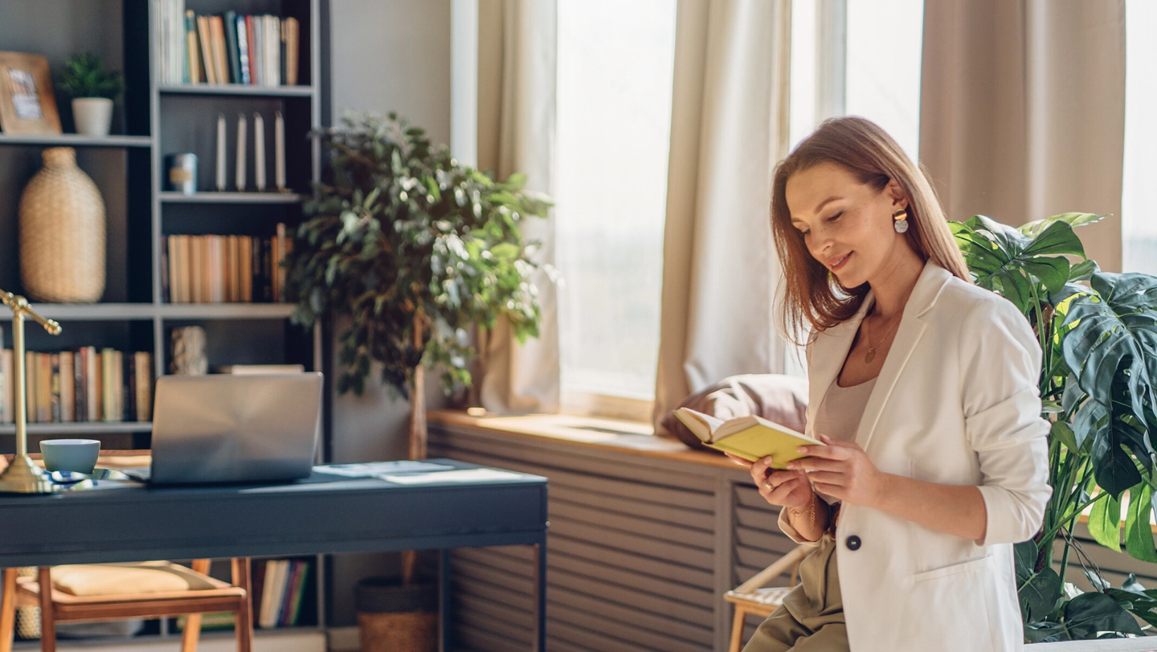 uśmiechająca się kobieta w marynarce czyta 